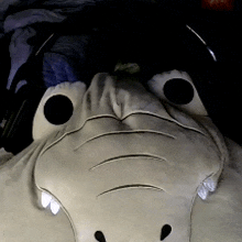 a stuffed animal that looks like a crocodile has headphones on it