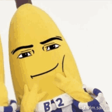 a stuffed banana with a face and gloves is making a funny face and looking at the camera .