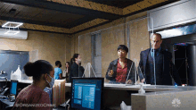 a woman wearing a mask sits at a desk in front of a computer screen that says organized crime on the bottom