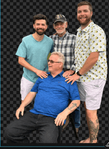 four men posing for a picture with one wearing a blue shirt