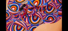 a woman is covered in a colorful pattern of swirls and circles