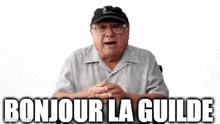 an elderly man wearing glasses and a hat is sitting in front of a white background and says bonjour la guilde .