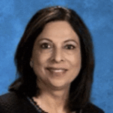 a woman is smiling for the camera in front of a blue background .