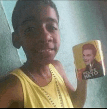 a young boy is holding a mug that says felipe neto on it .