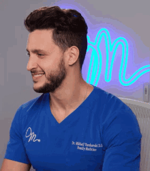 a man wearing a blue shirt that says dr. michal vonikowski d.o. family medicine