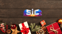 a wooden table with christmas presents and decorations and the word sic on top