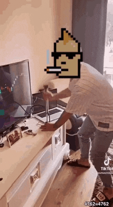 a man is standing in front of a television with a pixelated face on his face .