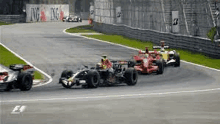 a group of racing cars on a track with a sign that says ing