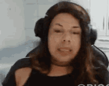 a woman is wearing headphones and making a funny face .