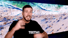 a man with a beard is saying teeth in front of a beach