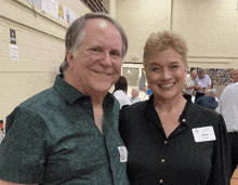 a man and a woman posing for a picture and the woman has a name tag that says carol