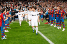 a man in a bwin jersey stands on a soccer field with other players