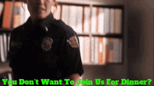 a woman in a police uniform stands in front of a bookshelf with the words you don 't want to join us for dinner