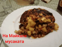 a white plate with a piece of meat and potatoes on it with the words " ha maikala musakata " on the bottom