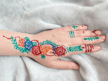 a woman 's hand with a colorful floral design on it