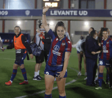 a woman in a levante ud jersey holds her arm up