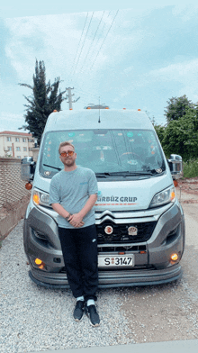 a man stands in front of a citroen van with a license plate that says s3147