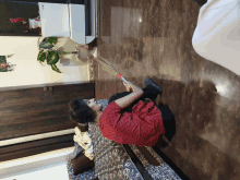 a woman laying on a bed holding a broom in her hand