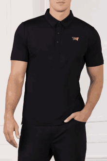 a man is wearing a black polo shirt with the letters pxg on the front