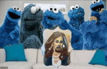 several cookie monsters are sitting around a pillow with jesus on it