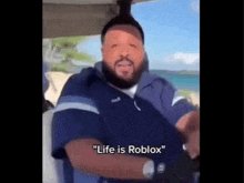 a man in a blue shirt is sitting in a golf cart and says `` life is roblox '' .