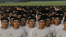 a large group of people wearing black hats and white shirts are standing in a field