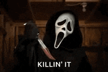 ghostface from the movie scream is holding a bloody knife in his hand .