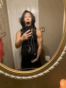 a man taking a selfie in a bathroom mirror