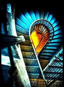 a spiral staircase with a blue railing and a yellow railing