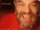 a close up of a man with a beard smiling