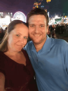 a man and woman posing for a picture at a carnival