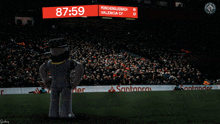 a man in a top hat stands in front of a scoreboard that reads 87:59