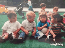 a group of children are sitting on the grass with a stroller in the background and the words imgplay at the bottom