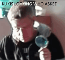 a man is holding a lollipop with the words kukis looking who asked above him