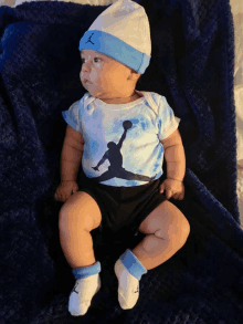 a baby wearing a blue and white jordan shirt