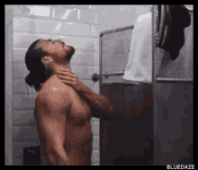 a shirtless man is taking a shower with a towel that says dolce gabbana on it