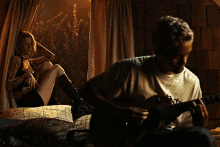 a man is playing a guitar while a woman sits on a window sill