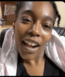 a close up of a woman 's face with a smile on her face while sitting in a chair .