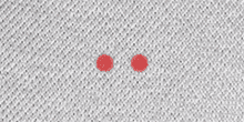 a close up of a white fabric with two red circles on it .