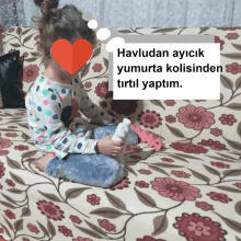 a little girl is sitting on a floral couch with the words havludan ayicik yumurta kolisinden tirtil yaptim