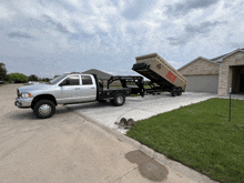 a dumpster is being pulled by a truck that says ' demolition ' on the side