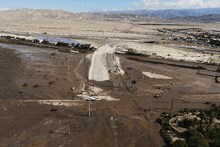 an aerial view of a flooded road with a bridge in the background