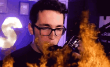 a man wearing glasses is smoking a cigarette with flames around his face