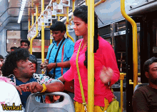 a woman in a pink shirt is standing next to a man in a blue shirt on a bus with the word venkat on the bottom