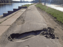 a hole in the asphalt on the side of a road