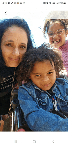 a woman and two children are posing for a picture and the woman is wearing a shirt that says ' take a picture '