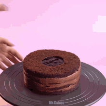 a chocolate cake on a black plate that says mr.cakes on it