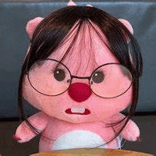 a stuffed animal wearing glasses and a wig is sitting on a table .