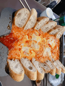 slices of bread are sitting on top of a pan with sauce and a bottle of sprite