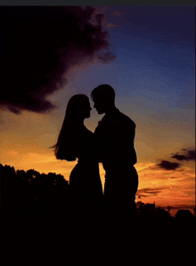 a silhouette of a man and a woman looking into each other 's eyes at sunset